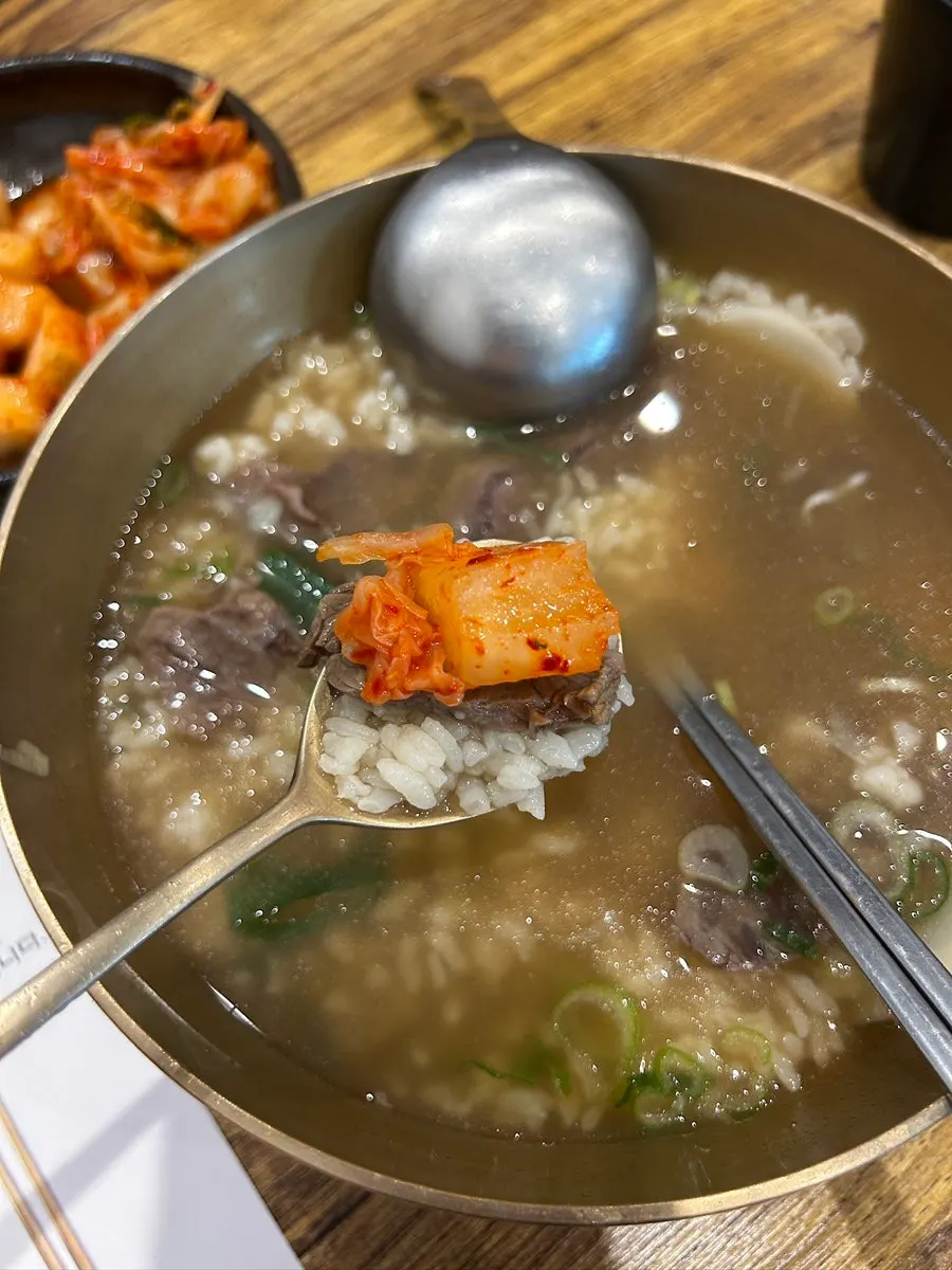 Eating gomtang together with kimchi