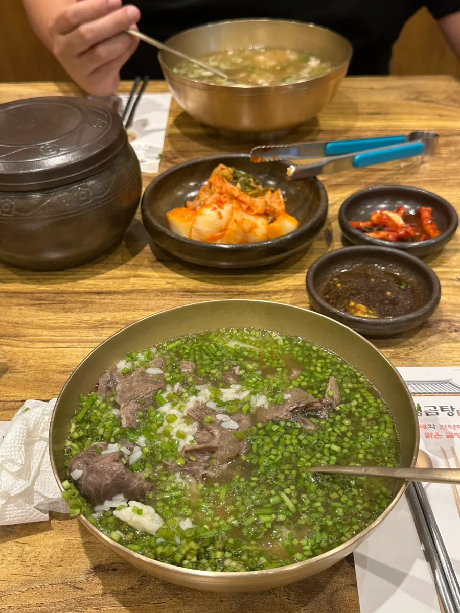 Two bowls: teuk gomtang and minari gomtang side by side
