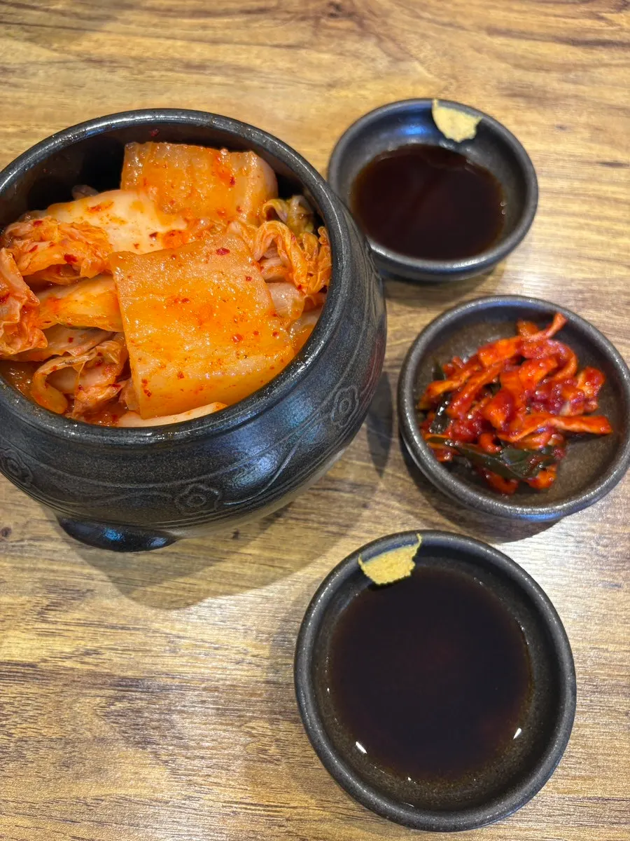 Seokbakji, geotjeori, and mumallaengi side dishes served in an earthenware bowl