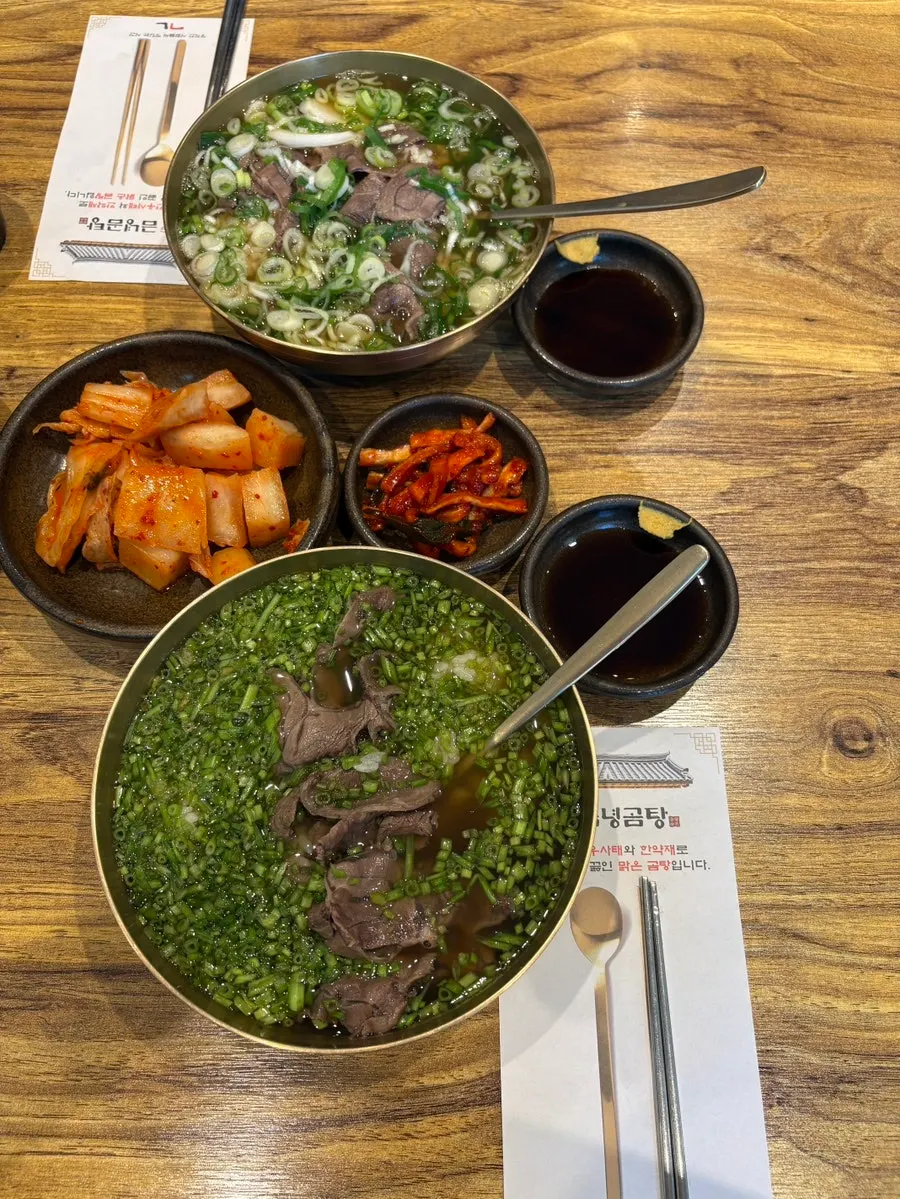 A table setting with gomtang and minari gomtang side by side