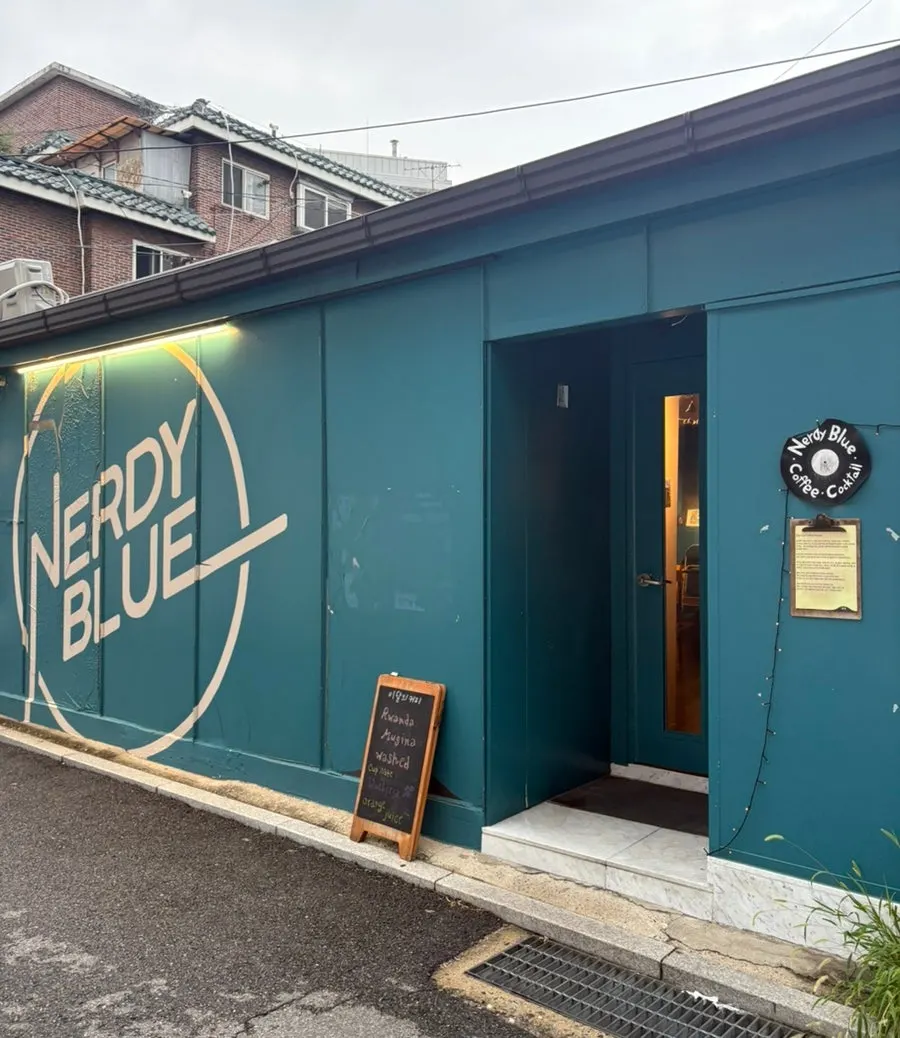 Café exterior with teal walls and logo