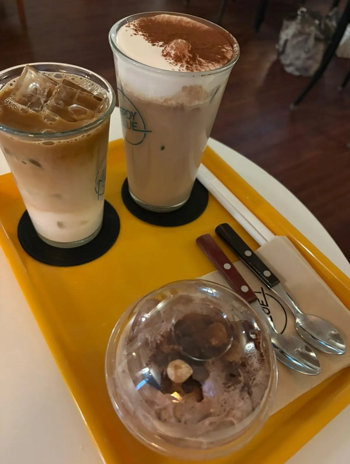 Drinks and choco pudding served on a yellow tray