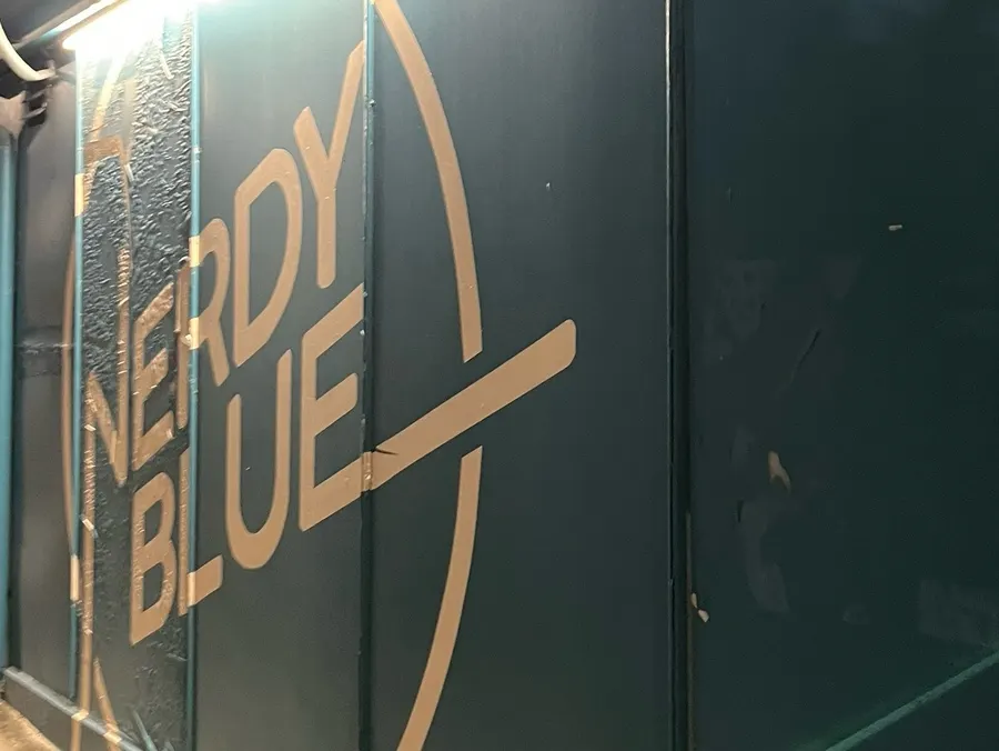 Blue exterior entrance of Nerdy Blue Burrow tucked in an alley
