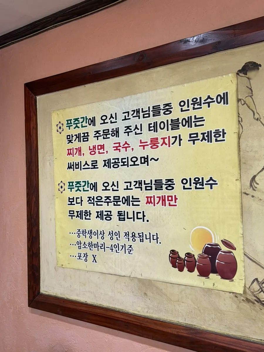 Sign explaining unlimited naengmyeon, nurungji, stew, and noodles