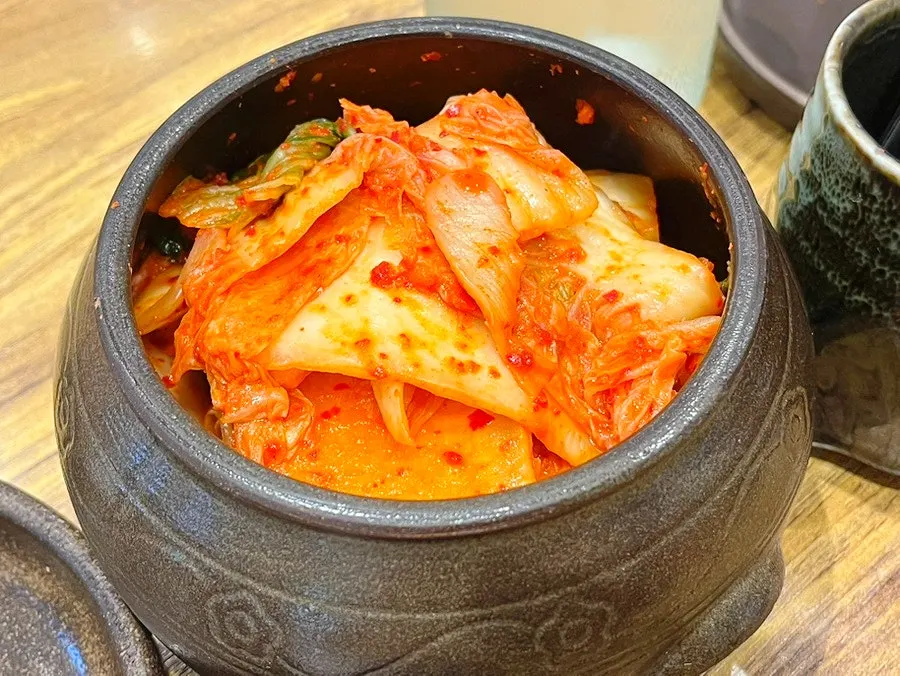 Side menu board listing myeongtaehoe muchim and boiled pork