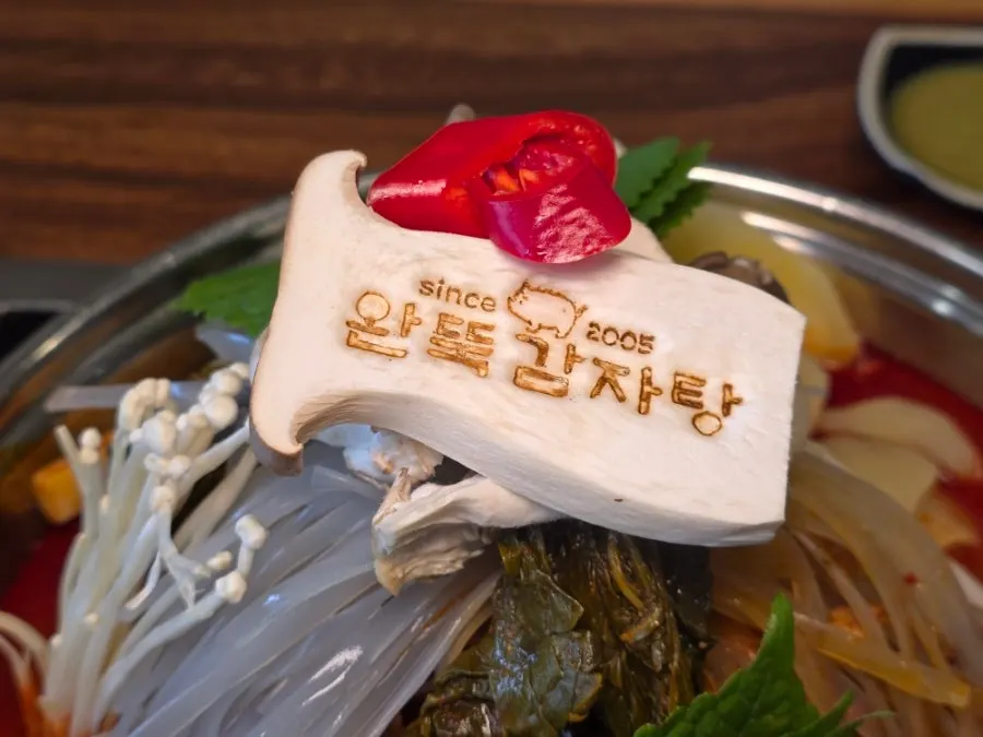 상호 도장을 찍어 올린 감자탕 위 버섯