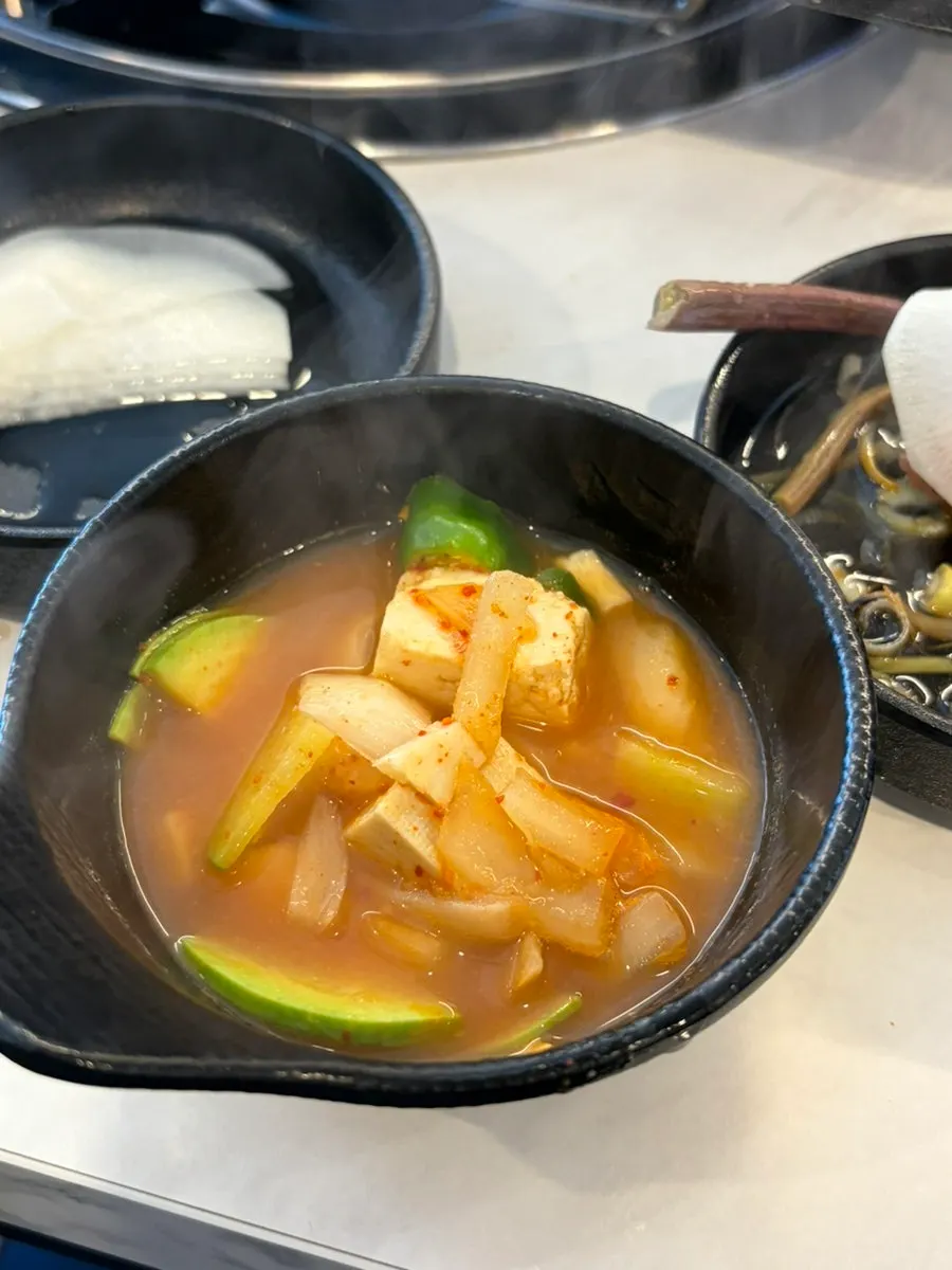 A spoonful of doenjang jjigae eaten alongside the meat