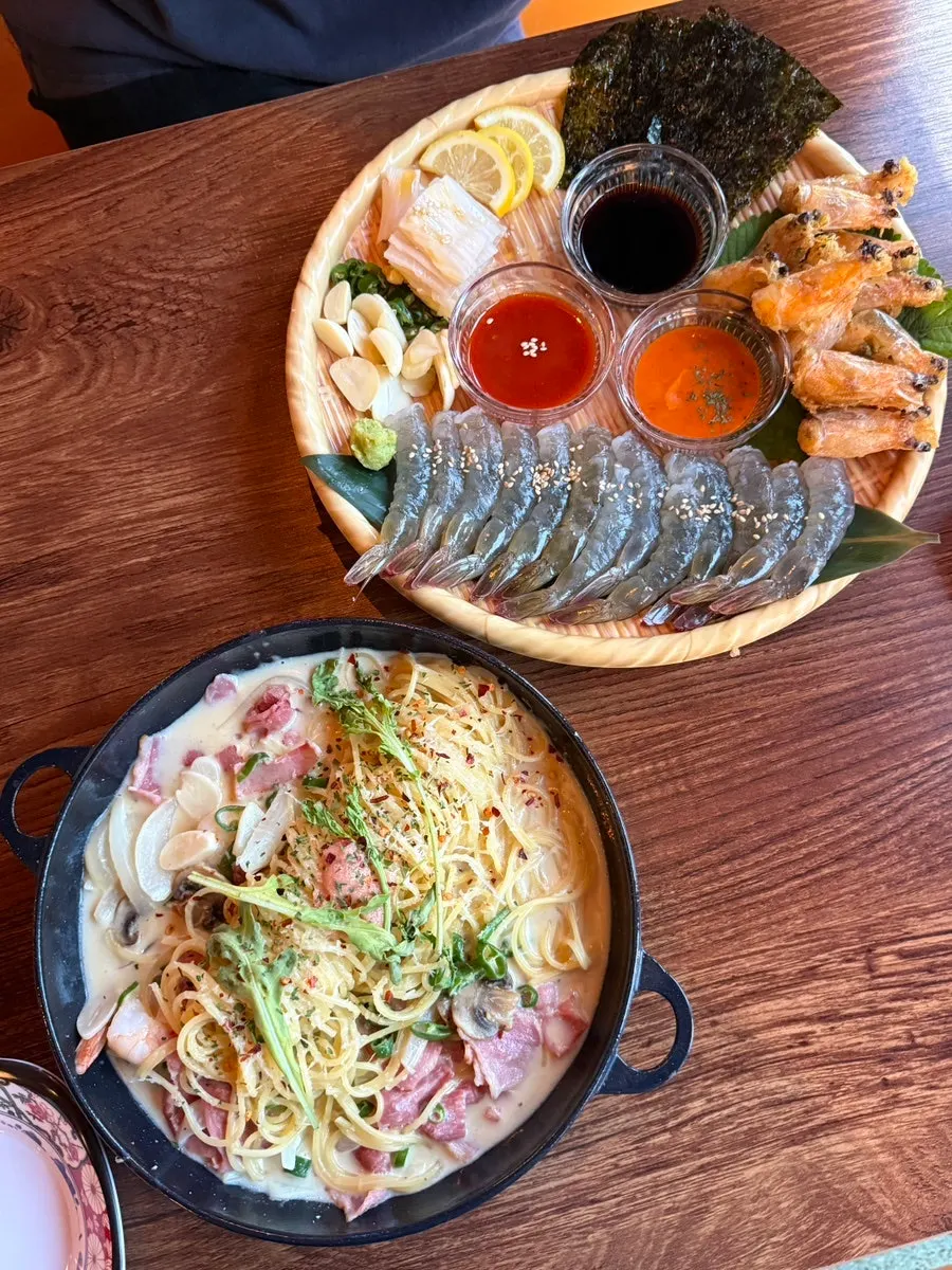 Table set with raw shrimp sashimi and myeongran cheongyang cream pasta