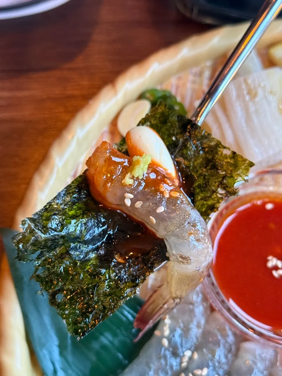 Raw shrimp sashimi wrapped in seaweed with garlic