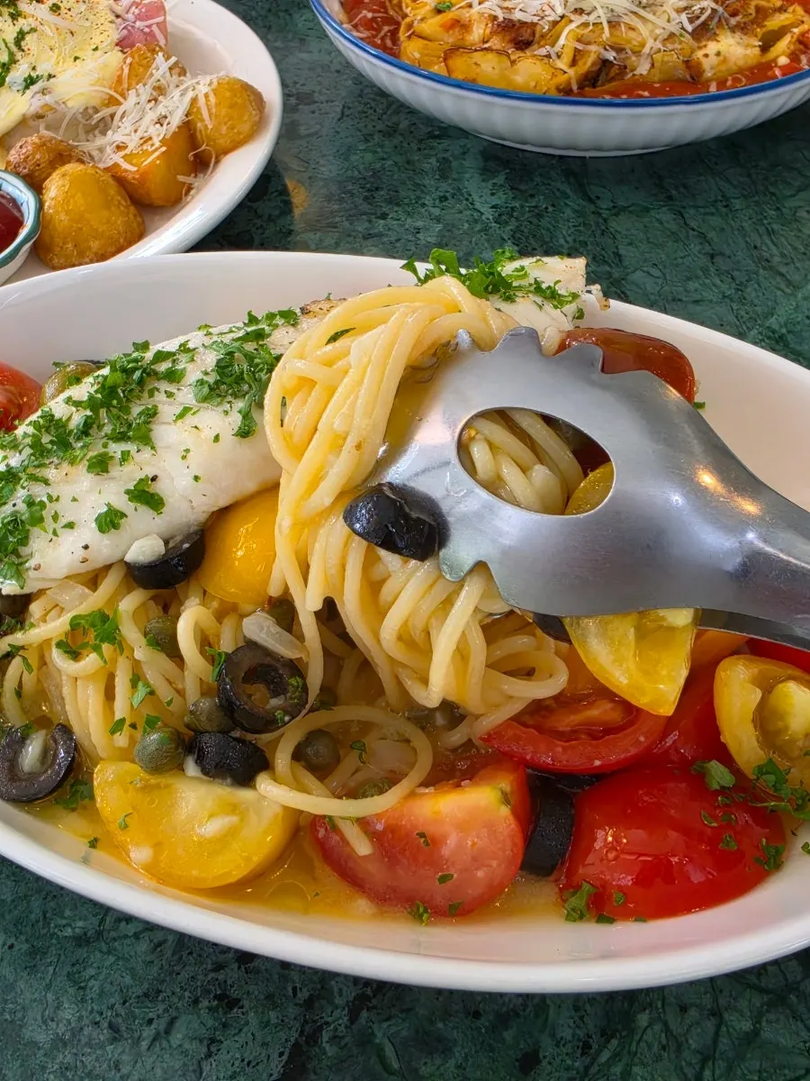Mediterranean pasta topped with fish and tomatoes