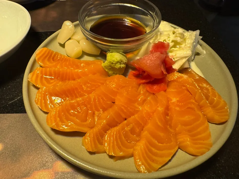 A plate of complimentary salmon sashimi