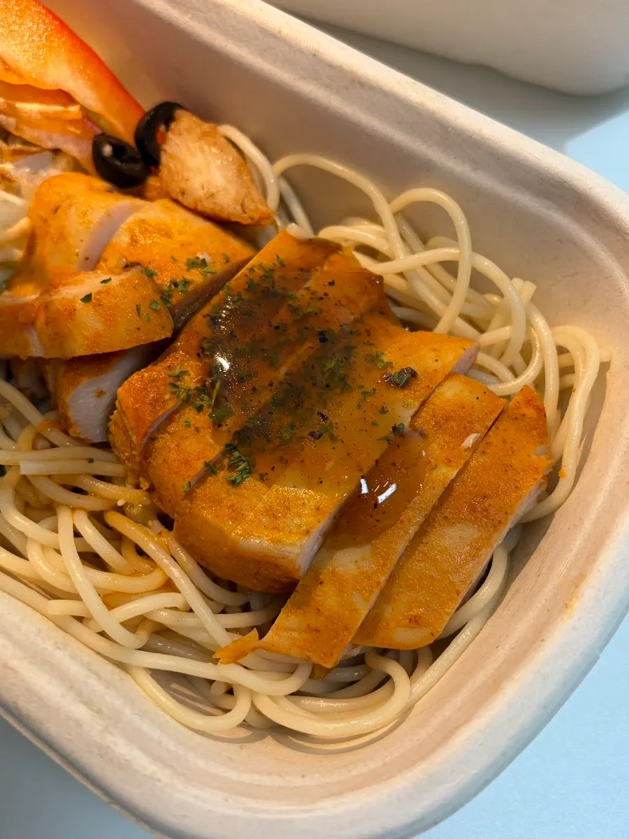 Pasta and salad in a protein box with sauce