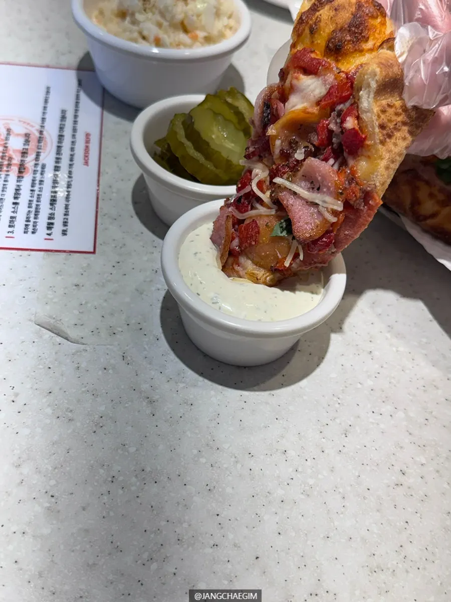 A slice of pizza picked up with a disposable glove