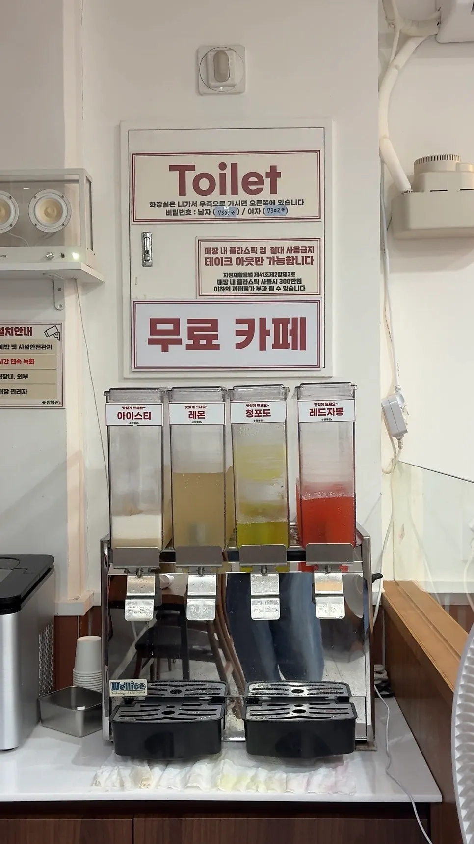 Corner of the restaurant showing the free rice and drinks notice