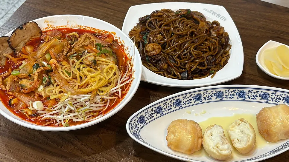 Table spread with seafood tray jjajangmyeon and chashu jjamppong