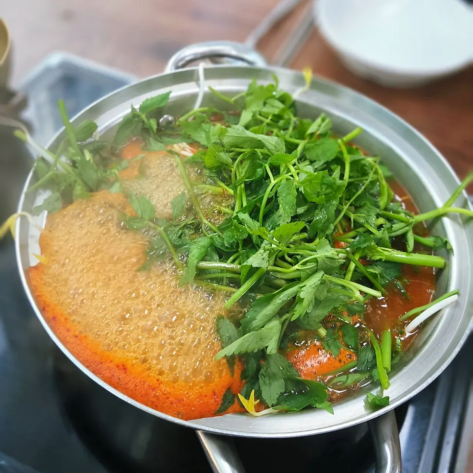 Pot of spicy broth shabu-shabu bubbling on the stove