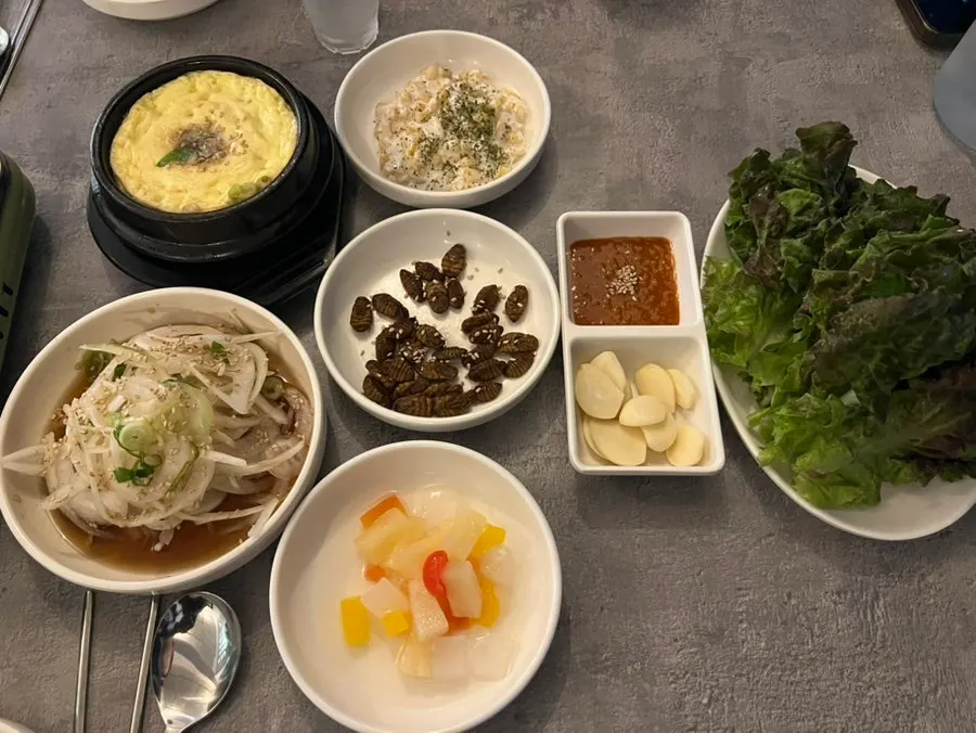 Table spread with steamed egg, pickled onion and other side dishes