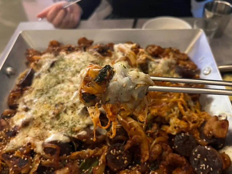 A big scoop of vegetable cheese gopchang with cheese and glass noodles
