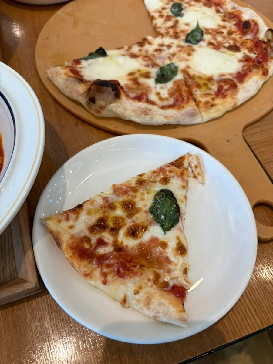 A slice of thin-crust margherita pizza
