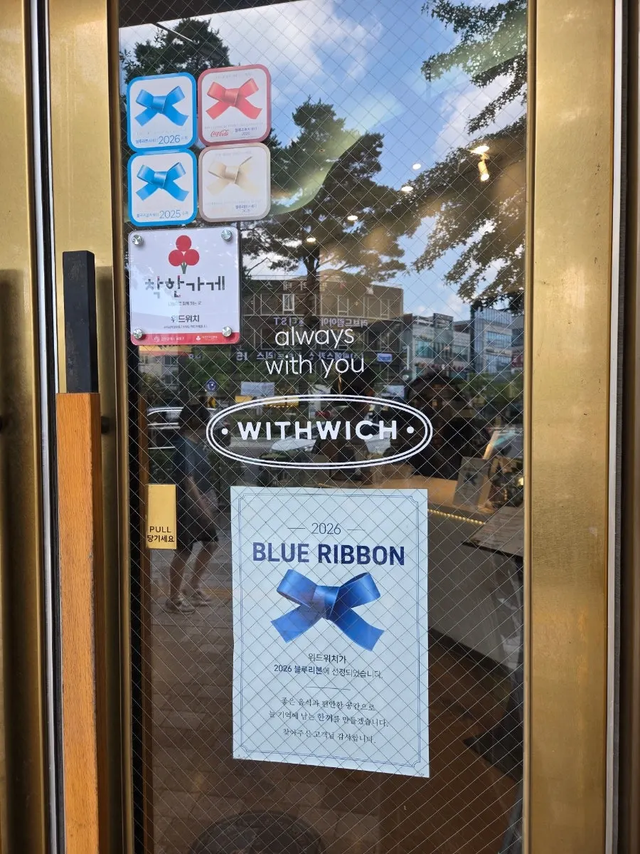 Withwich's storefront entrance with business hours signage
