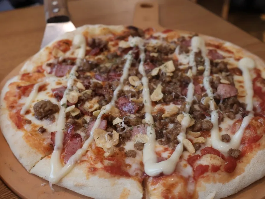 A slice of bulgogi wood-fired pizza showing the chewy dough