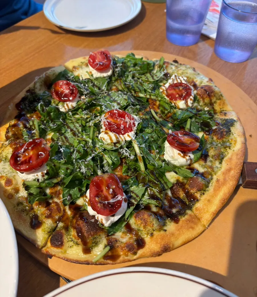 Ricotta cheese pizza piled high with arugula