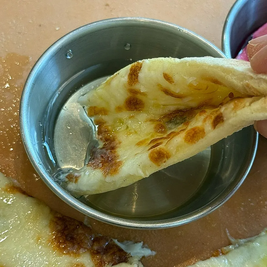 A slice of gorgonzola pizza showing its chewy dough