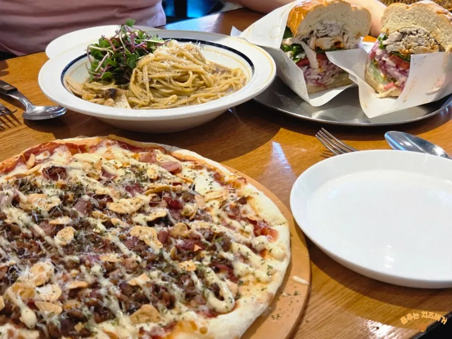 Withwich pasta and pizza laid out on the table