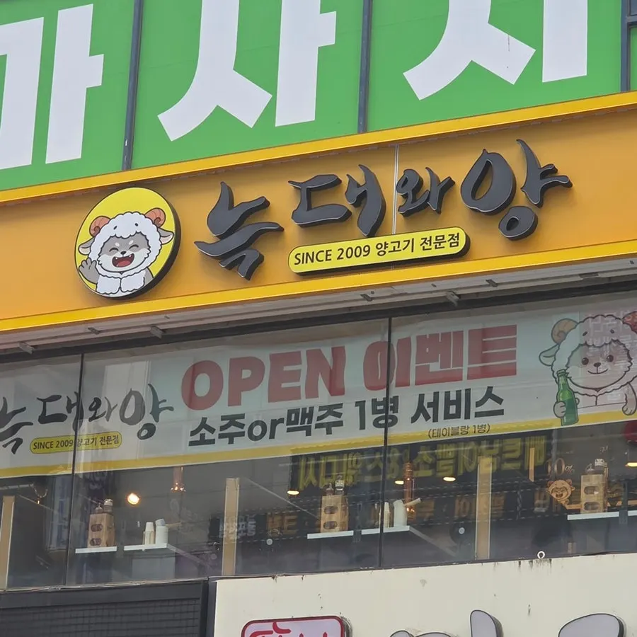 노란색 간판이 보이는 늑대와양 삼산점 건물 외관