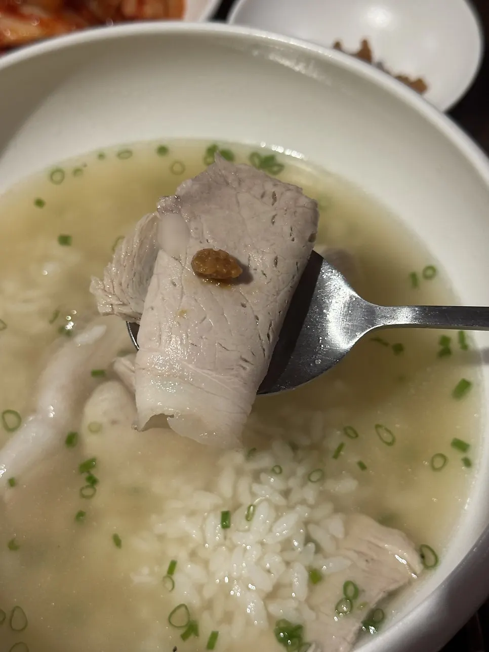 Inside the bowl showing tender boiled meat and rice mixed into the soup