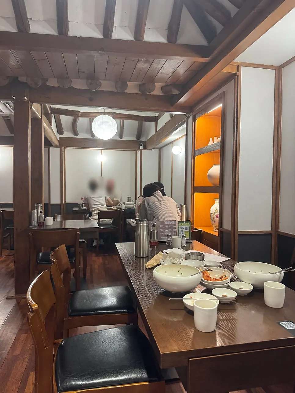 A meal scene with gomtang broth and kimchi on the side