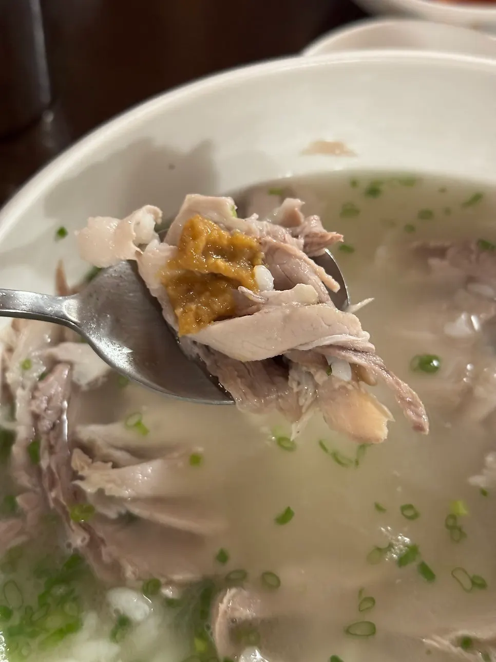 A spoonful of the clear pork gomtang broth