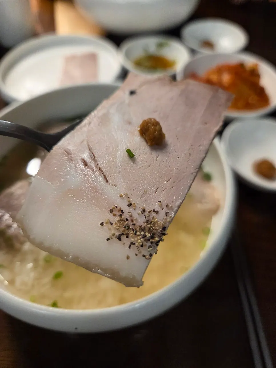 냉제육 한 점을 집어 든 모습