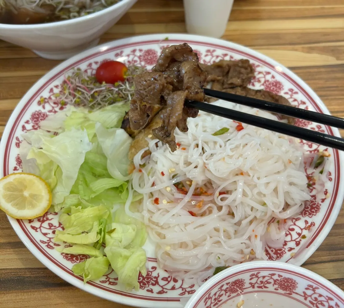 บุนจ่าคำหนึ่งที่มีหมูย่างไฟและผัก