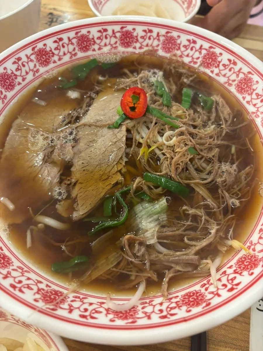 Lifting up a bite of pho noodles