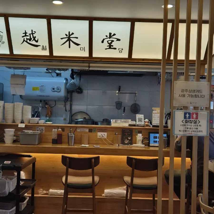 White and wood-toned interior of Wolmidang with bar seating for solo diners