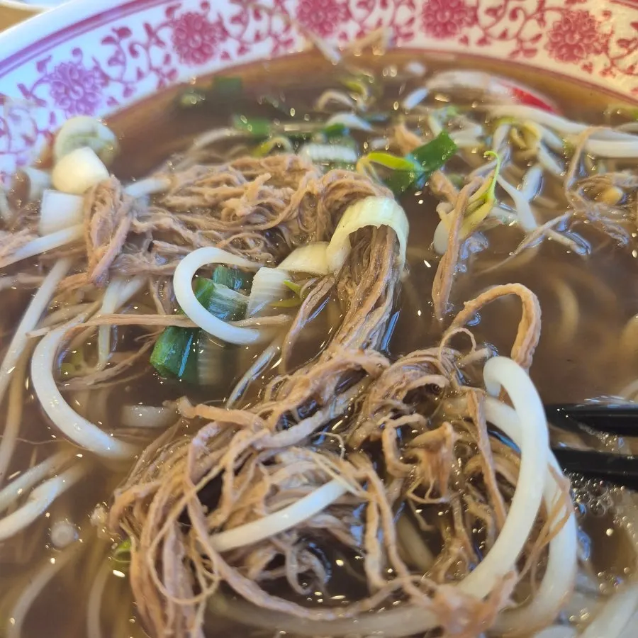 Pho topped with beef brisket shredded along the grain