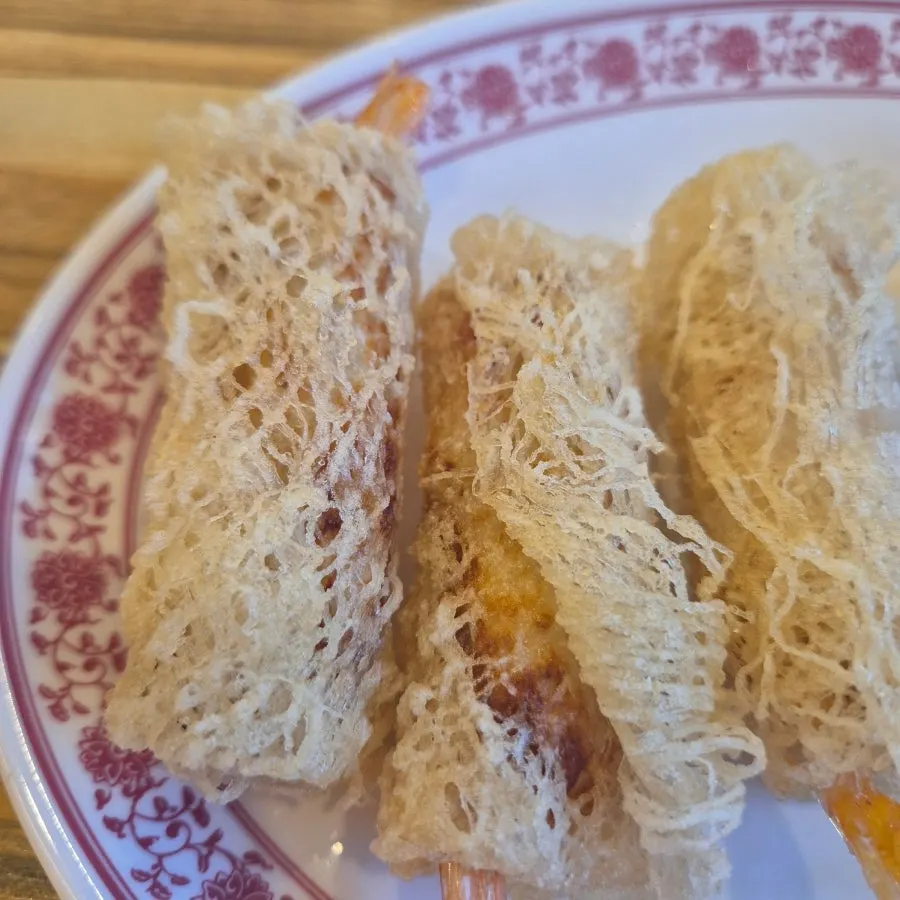 Three pieces of shrimp cha gio fried in a thin wrapper
