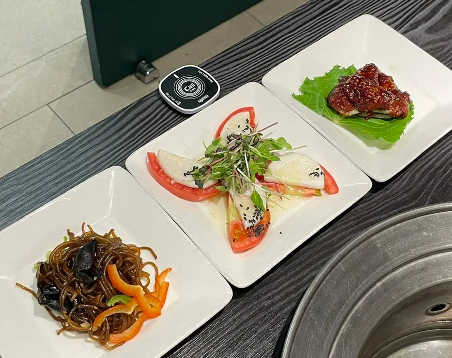 Plates of japchae, marinated crab, and other banchan