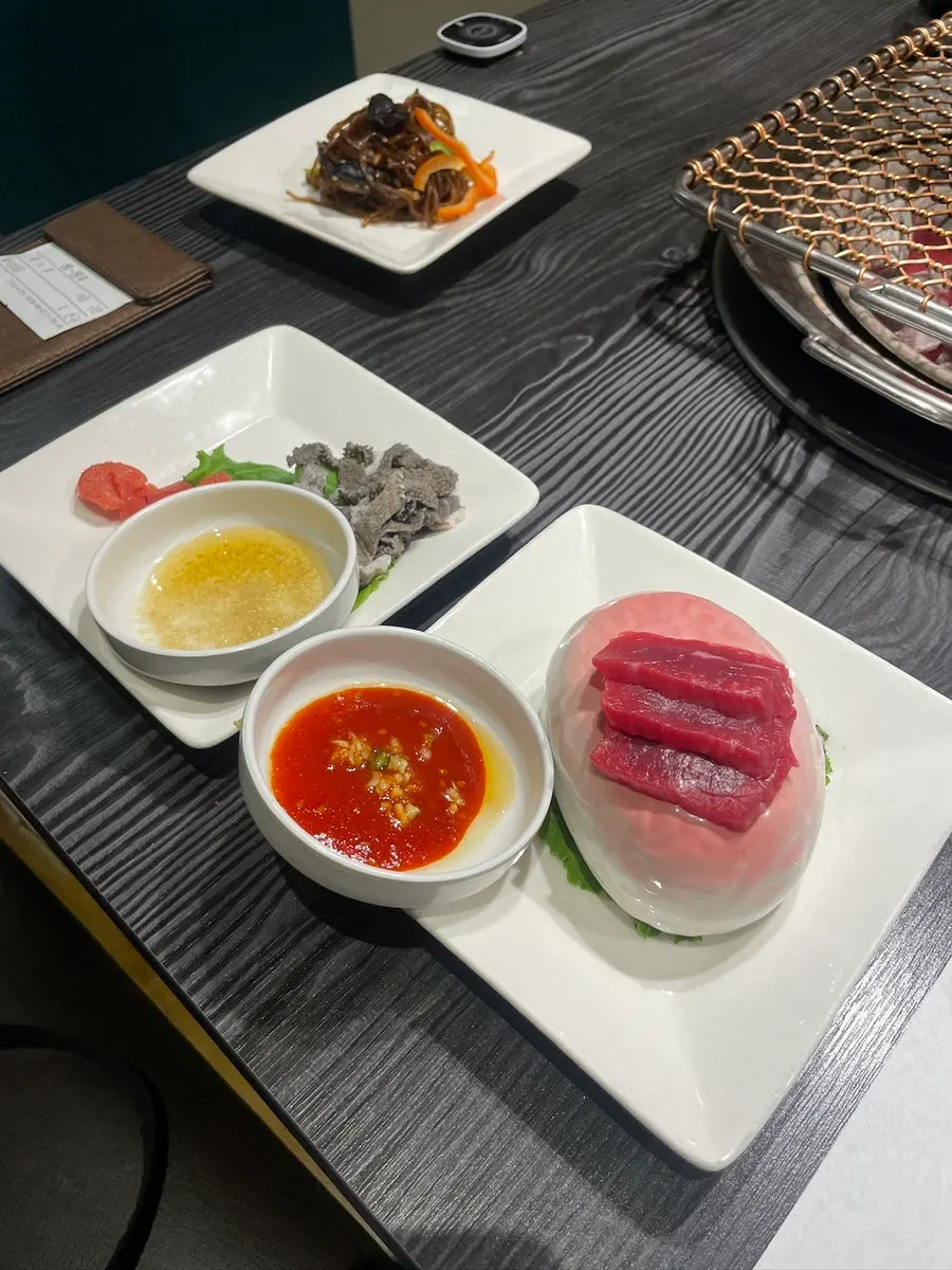 Raw beef sashimi, beef tripe, and pollock roe side dishes