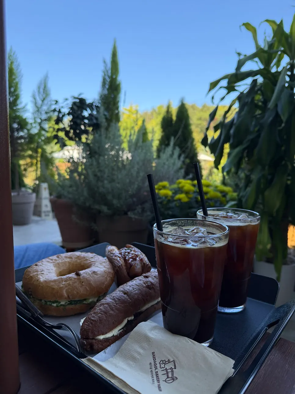 Americanos and three kinds of bread at an outdoor garden seat