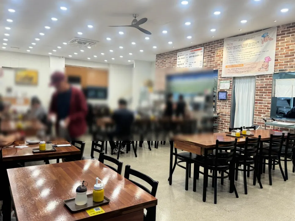 Brightly lit dining room with wooden tables at Bongpyeong Gohyang Makguksu