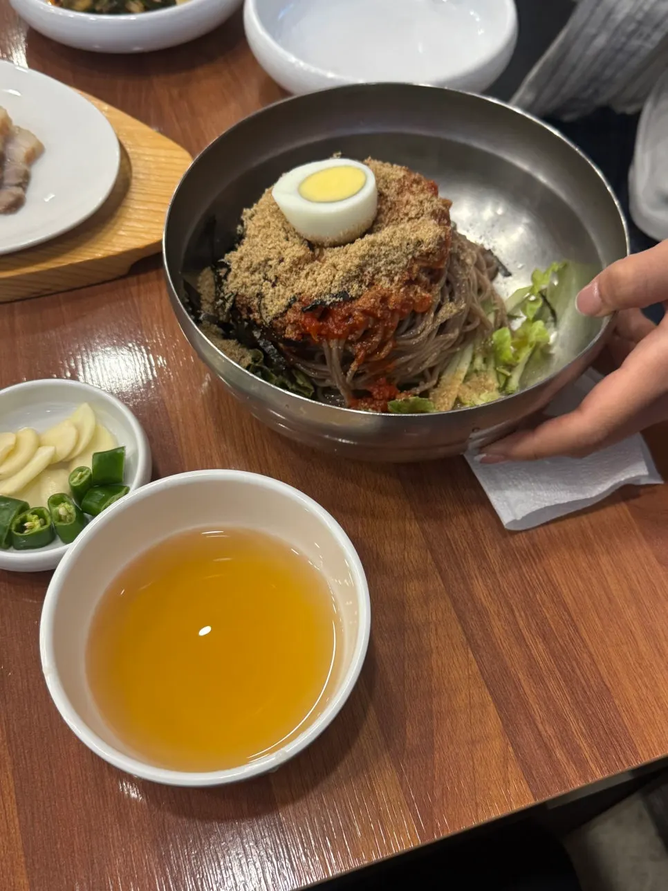 Bowl of clear broth served alongside the bibim makguksu