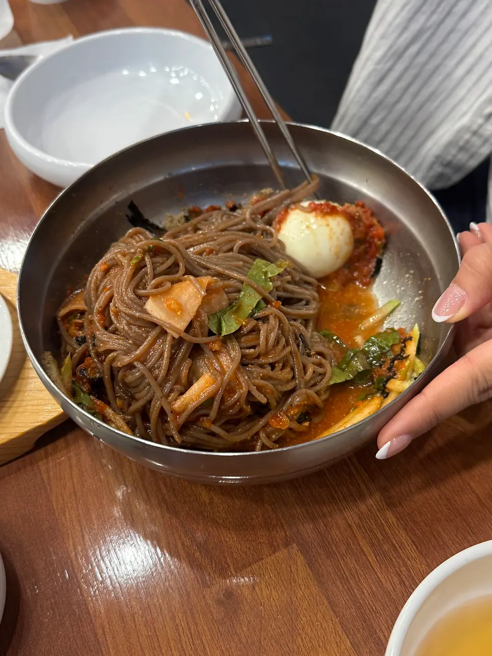 Bibim makguksu lifted up with chopsticks