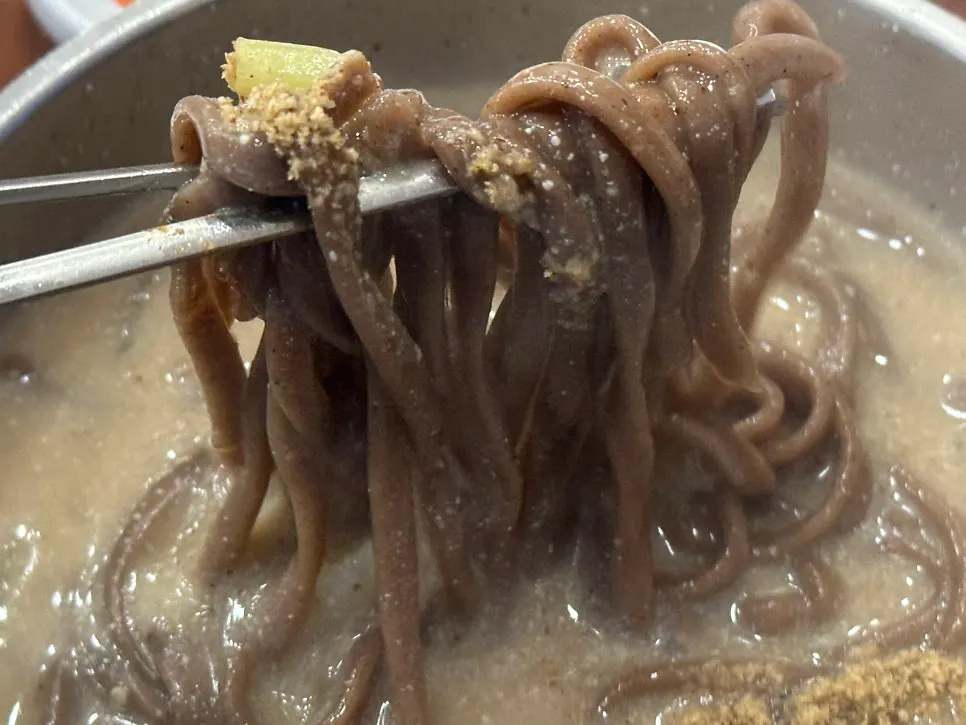 Close-up of the thick perilla broth with visible perilla powder grains