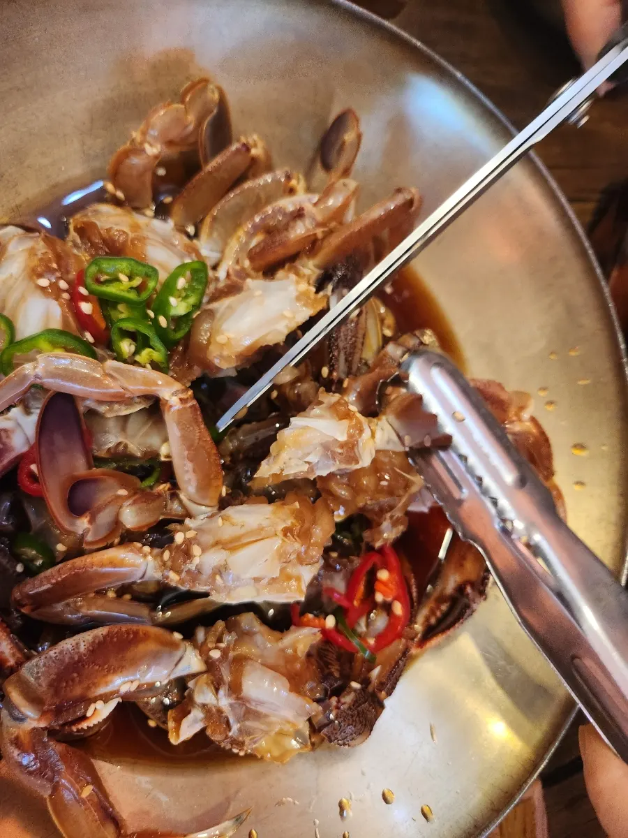 A piece of ganjang gejang picked up with tongs