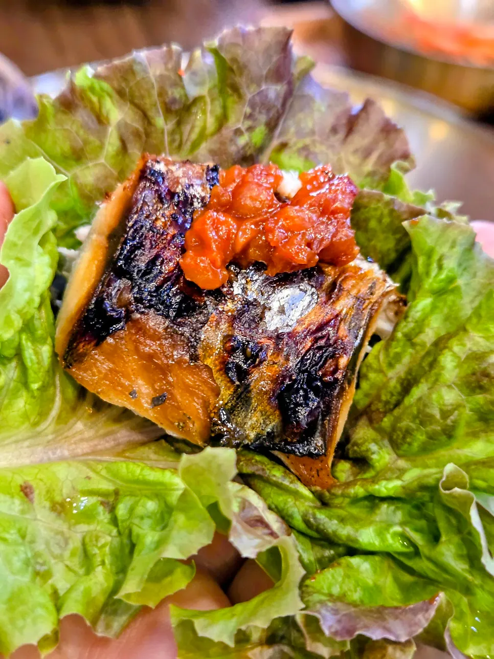 A piece of grilled mackerel picked up with chopsticks