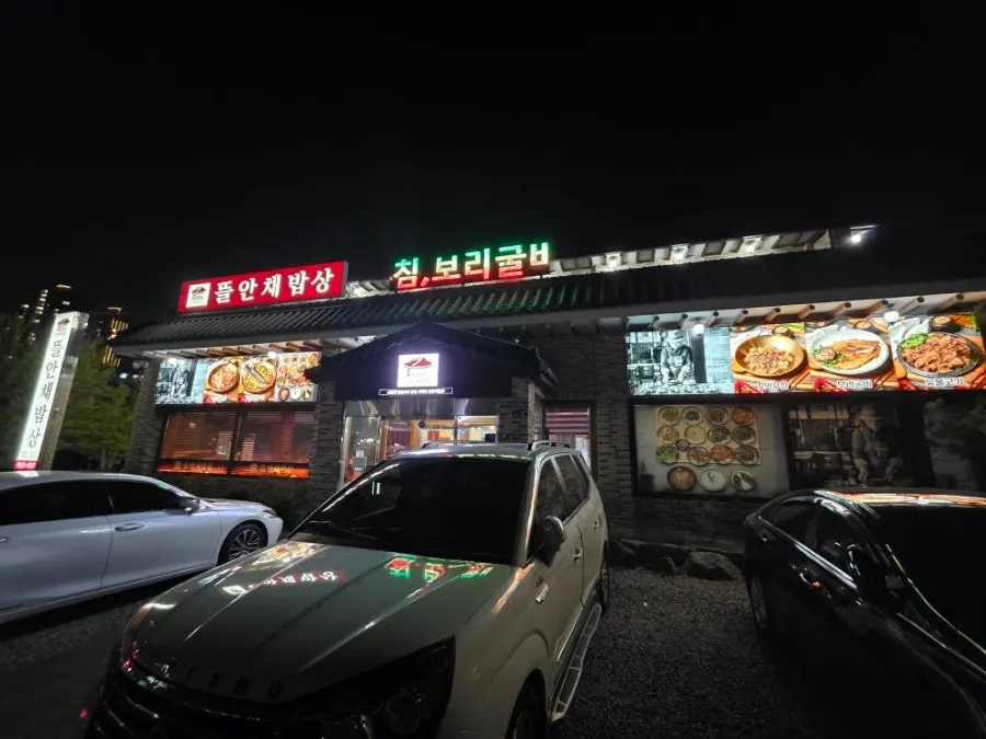 기와를 활용한 한정식집 건물과 앞쪽 주차 공간