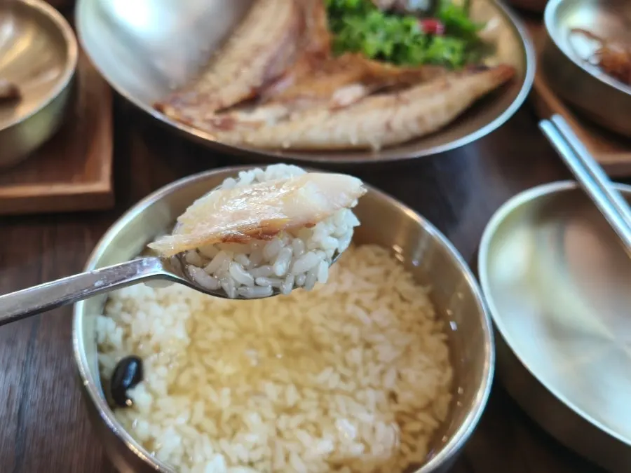 A spoonful of green tea rice topped with dried corvina flesh