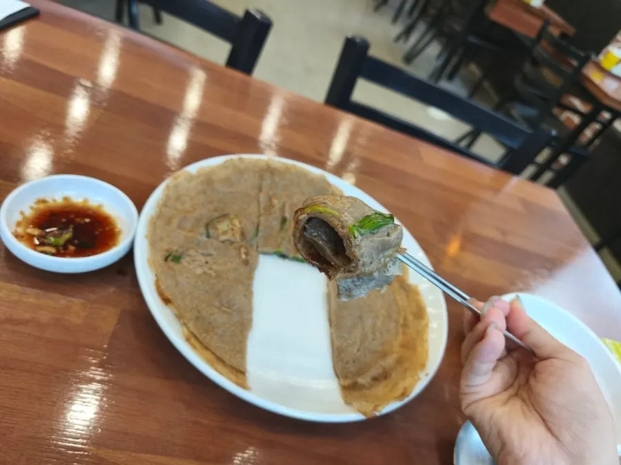 간장양념에 찍어 먹는 메밀부침개 한 조각